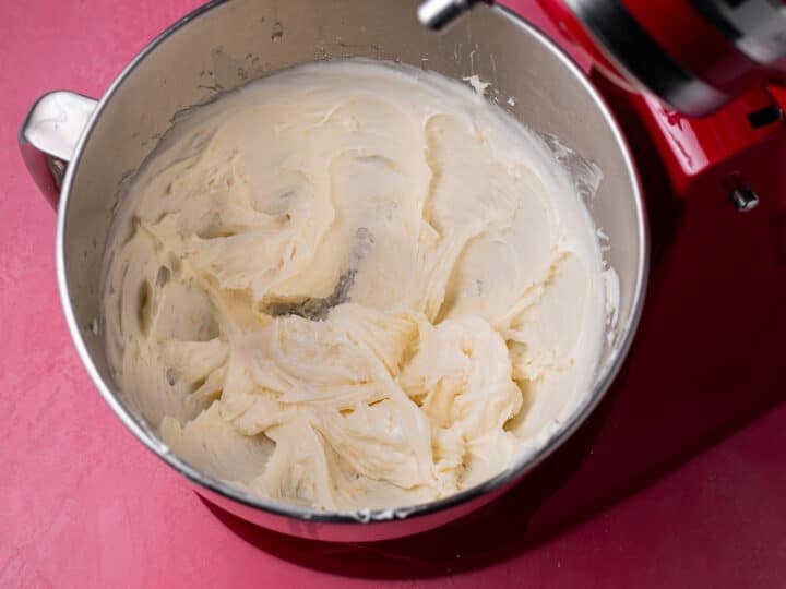 Creamy lemon cream cheese frosting mixed in the bowl of a stand mixer.