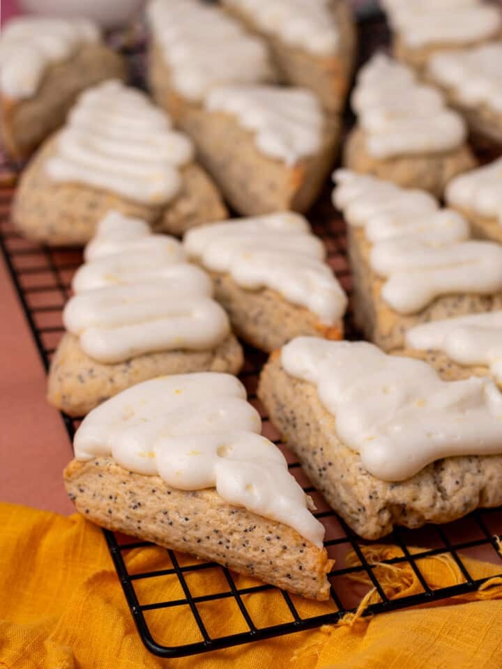 Close-up of lemon poppyseed scones topped with swirls of lemon cream cheese frosting.