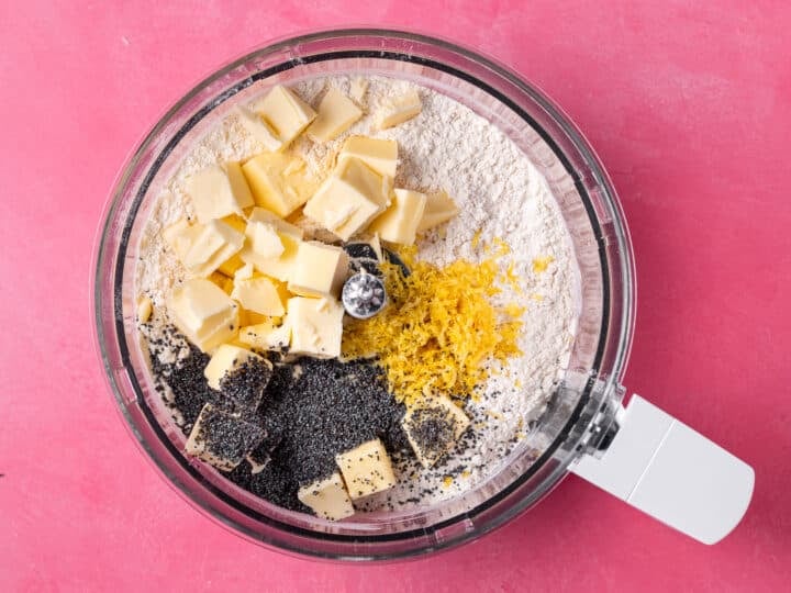 Cubed cold butter, fresh lemon zest and poppy seeds added to the flour mixture in a food processor.