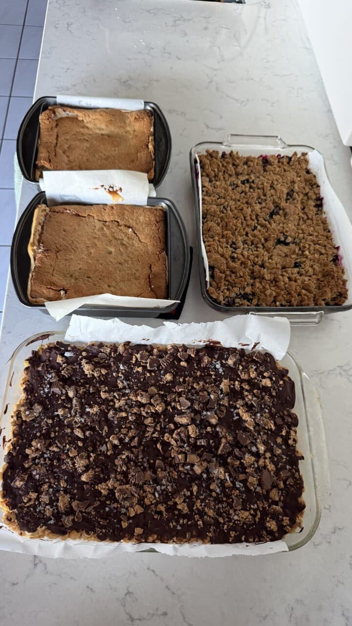 berry crisp, chocolate peanut butter rice krispie treats, and other baked goods cooling on counter as some of the best camping food