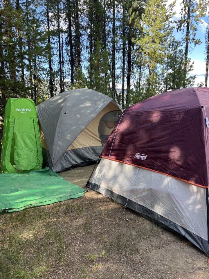 two tents and a pop up porta-potty for the camping setup