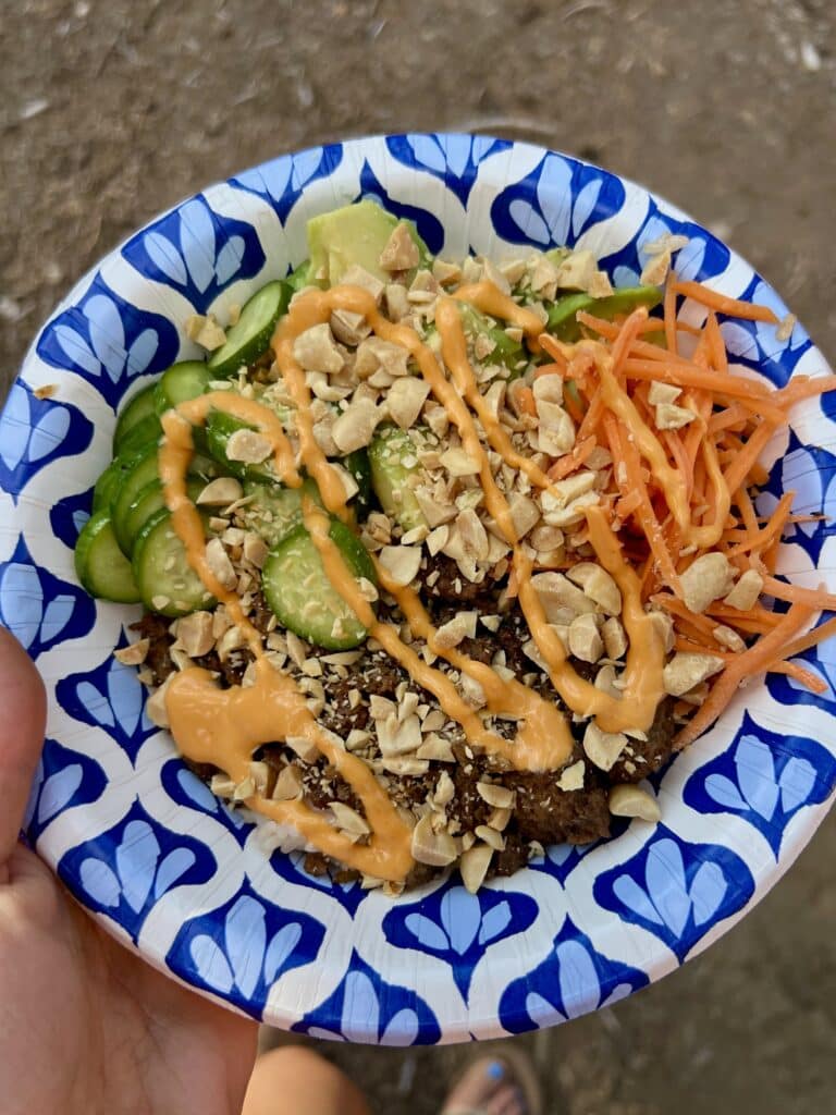 cucumbers, shredded carrots, Korean shredded beef, crushed peanuts, and sriracha mayo piled on a rice bowl