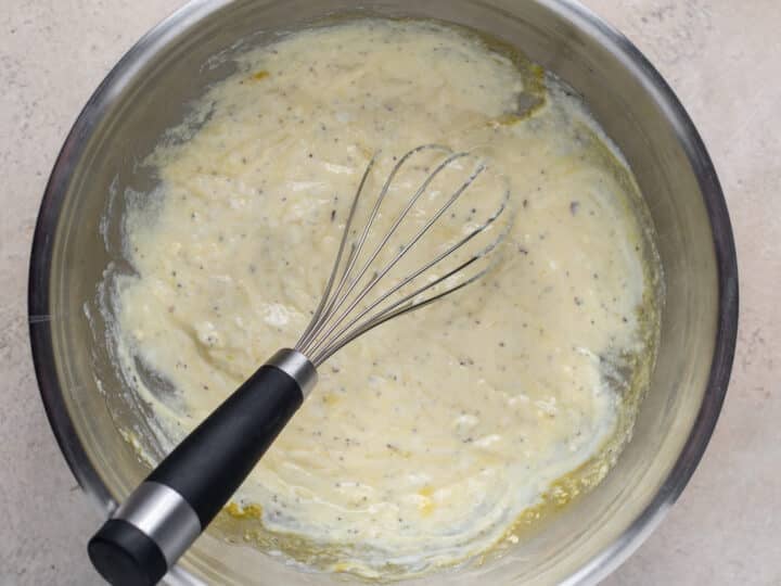 Whisked ricotta, egg, garlic and seasoning mixture in a stainless-steel bowl.