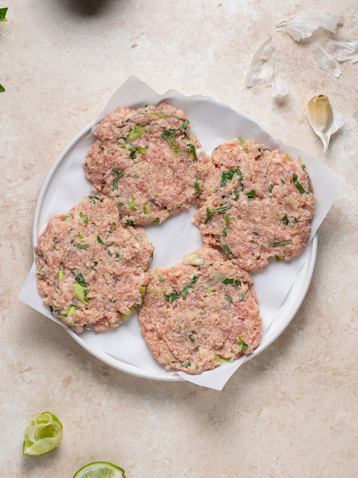 uncooked chicken patties shaped and placed on parchment paper for freezer meal prep