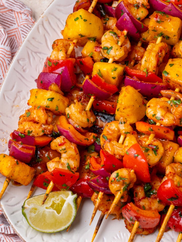 Close-up of grilled shrimp and pineapple skewers with caramelized pineapple, red peppers, red onion and fresh cilantro.