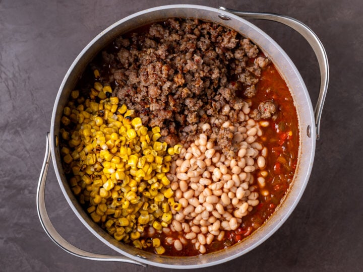 White beans, roasted corn and browned Italian sausage added to the seasoned broth and vegetables.
