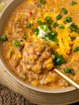 Close-up of thick white bean chili with shredded chicken, Italian sausage, roasted corn and creamy white beans.
