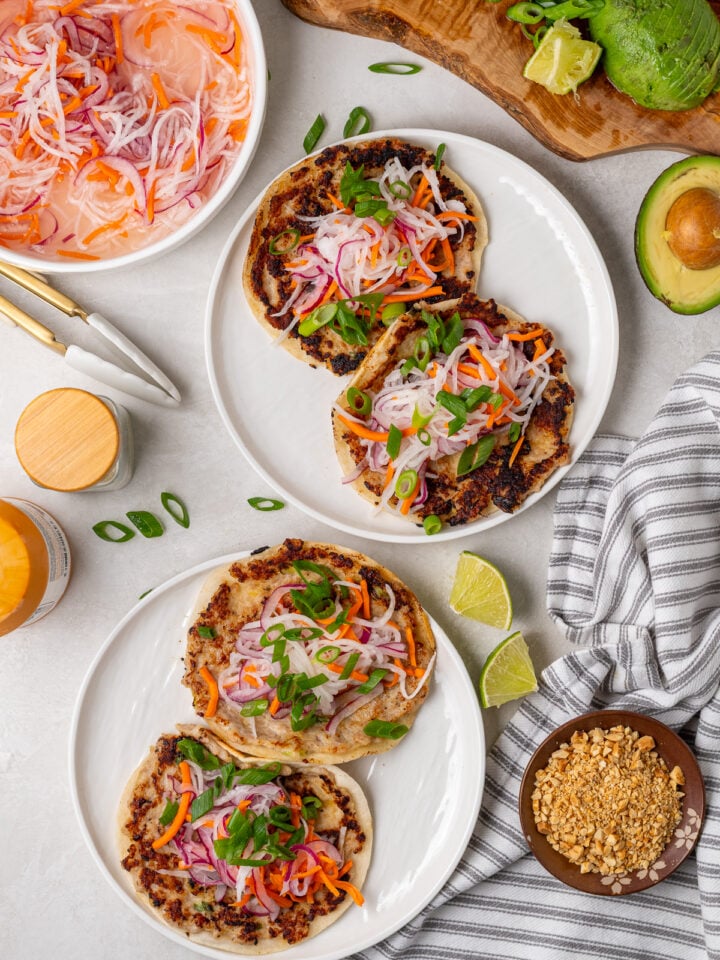 Crispy chicken smash tacos topped with quick-pickled vegetables and sliced green onions.