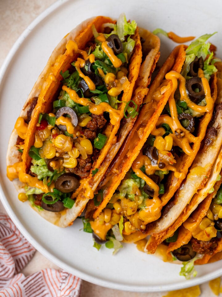 Close-up of finished cheesy gordita crunch recipe with chipotle sauce and fresh toppings.