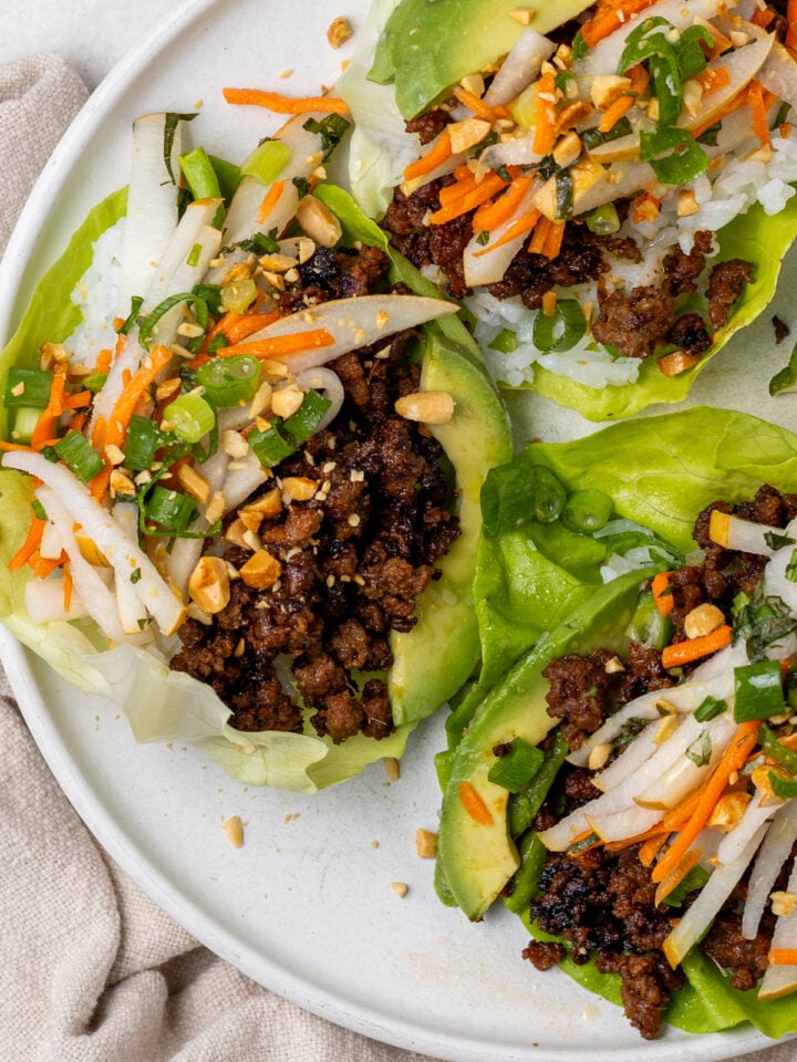 Korean lettuce wraps filled with caramelized beef, pear slaw, avocado, fresh herbs and peanuts