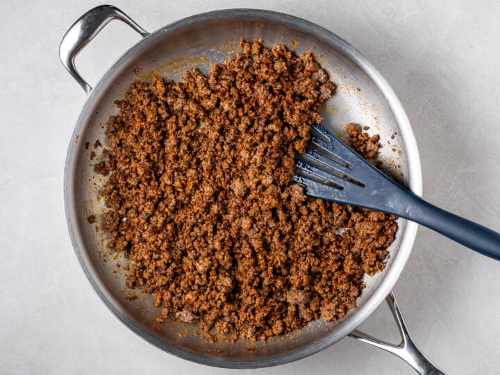 Caramelized gochujang ground beef cooking in a large skillet