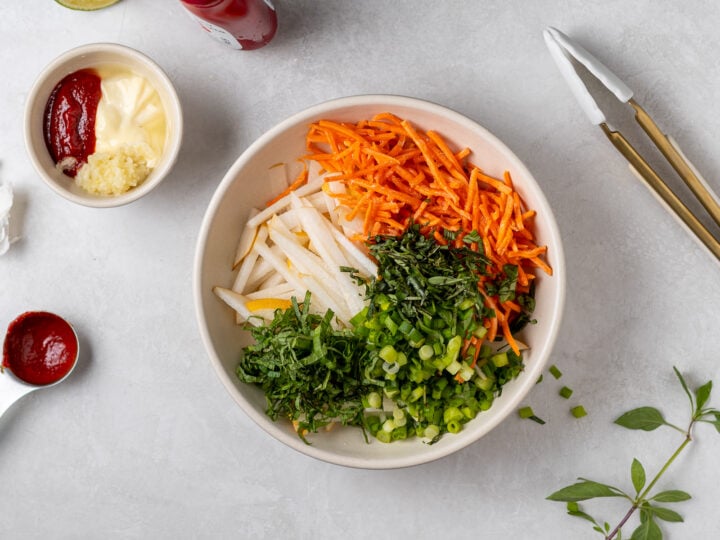 Asian pear slaw ingredients with shredded carrots, Thai basil, mint and sliced green onions