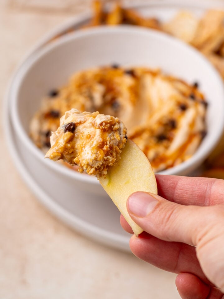 Apple slice dipped into creamy peanut butter yogurt dip