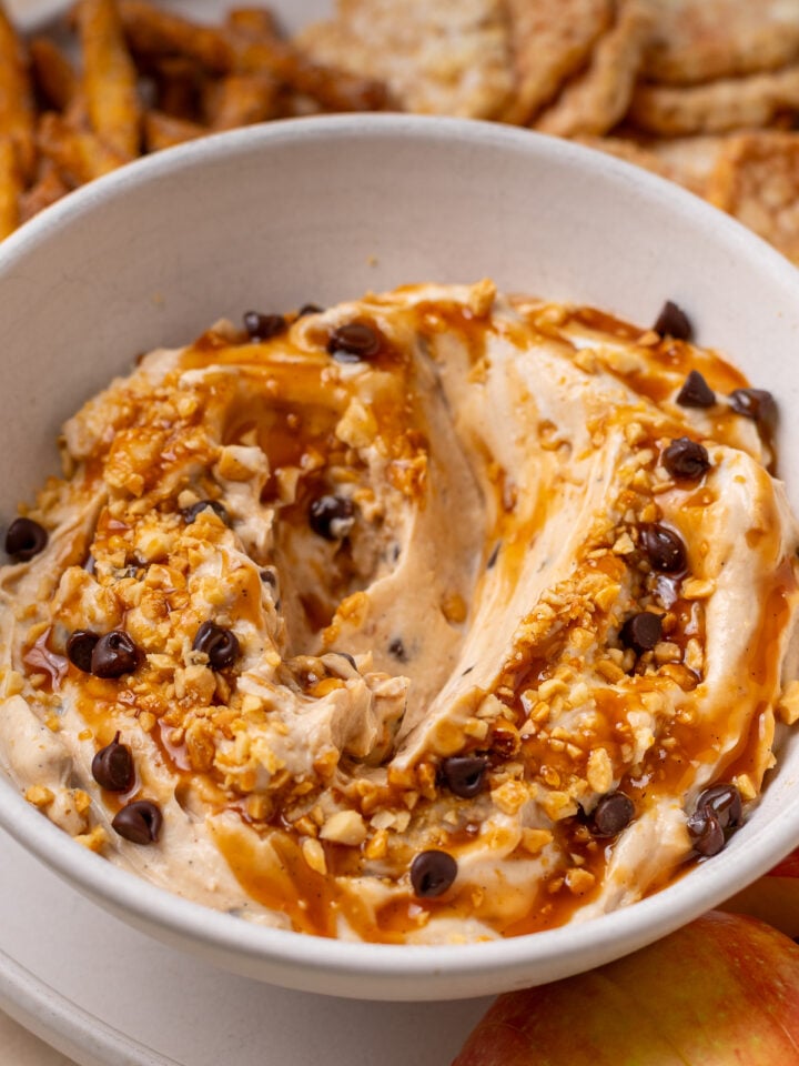 Close-up of caramel apple dip topped with mini chocolate chips and crushed peanuts