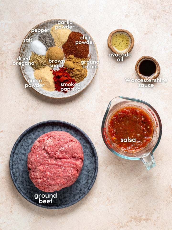 Labeled ingredients for homemade taco meat, including raw ground beef, salsa, avocado oil, Worcestershire sauce, brown sugar and spices.