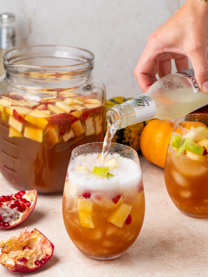 Topping a glass of fall sangria with ginger beer for a refreshing, bubbly finish.